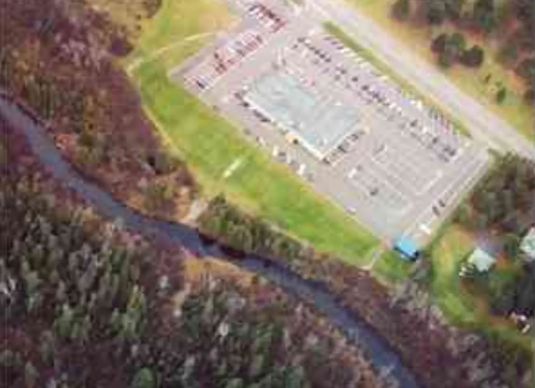 business next to river Drone view of parking lot next to river